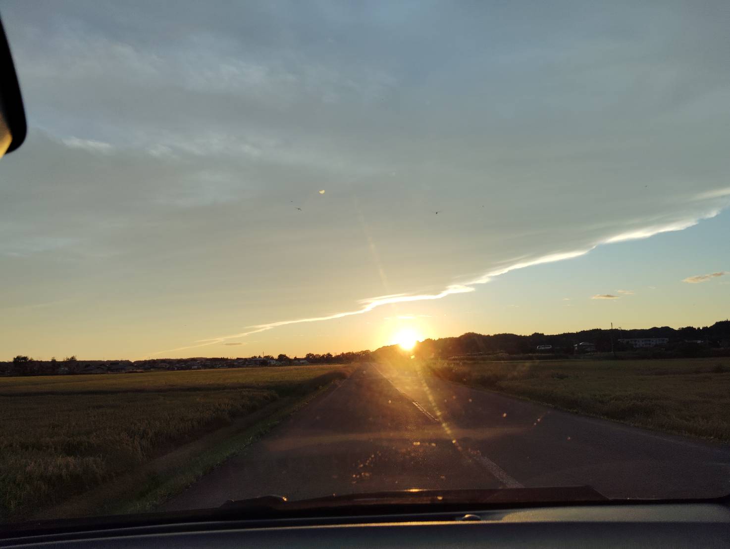 Sunset over fields seen from a car